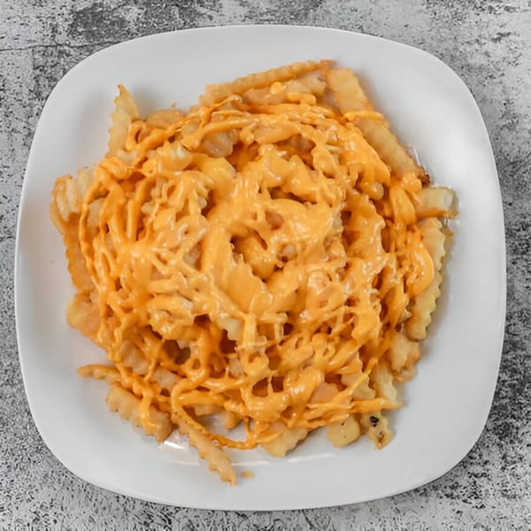 Milan's Real Philly Cheesesteaks and Hoagies' crinkle-cut fries generously topped with melted cheese sauce.